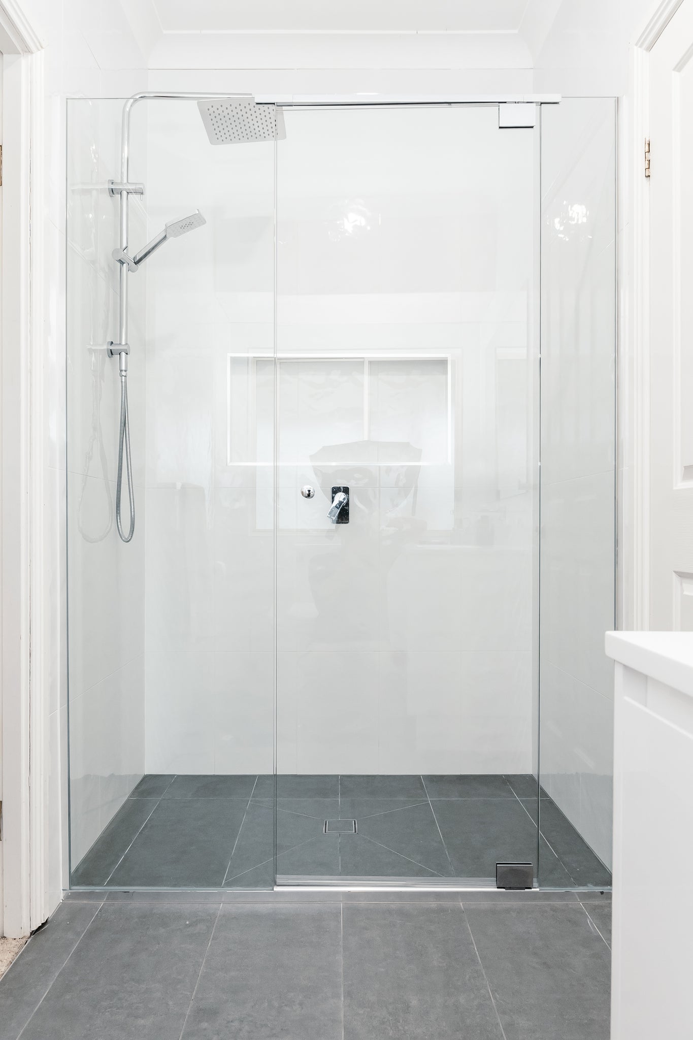 Clean frameless glass shower enclosure in a modern bathroom